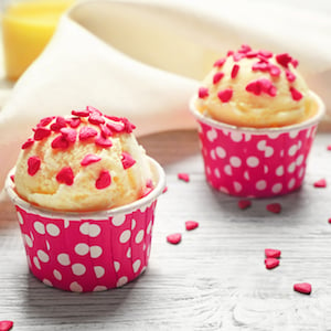 Cups with tasty ice cream and sprinkles on wooden table