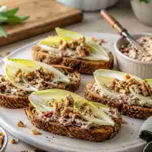 Sun-dried tomato endive appetizer with mushroom cream cheese, walnuts, sage, and toasted Mestemacher mixed cereal bread